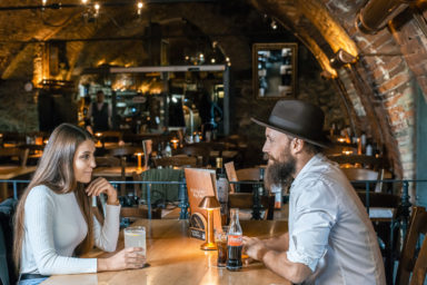 Pärchen sitzt am Tisch und trinkt Cola und Mineral mit Zitrone