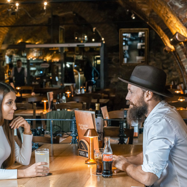 Pärchen sitzt am Tisch und trinkt Cola und Mineral mit Zitrone